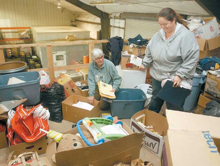 Volunteers Jody Ayars, left, and Linda Jaquez sort through boxes
of donated goods Thursday at the Community Pantry's new building at
1133 San Felipe Road in Hollister.