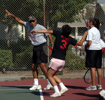 Head coach Ed Cecena helped players with their serves at a San
Benito High girls tennis team practice.