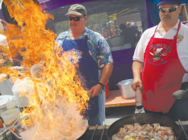 DELISH DISH John Vickory and Bruce Parker fire up the mushroom and shrimp scampi for the Gilroy Elks booth at the 36th annual Mushroom Mardi Gras. Photo Robert Eliason