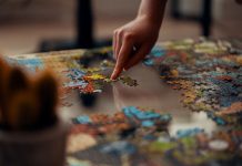 Person holding jigsaw puzzle pieces