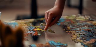 Person holding jigsaw puzzle pieces