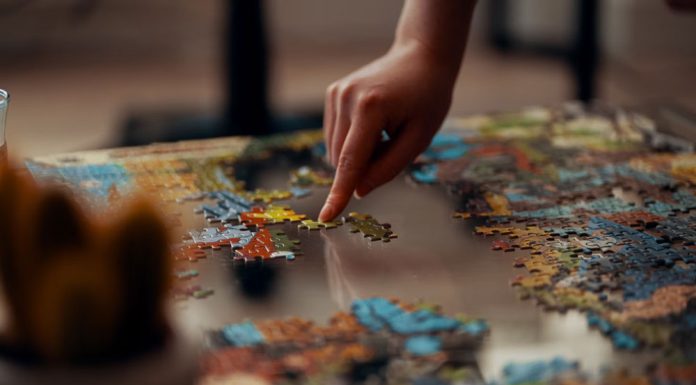 Person holding jigsaw puzzle pieces